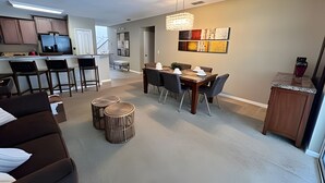 A modern apartment with a dining area, kitchen, and living space. - New to Market Spacious Private Pool Retreat (Kissimmee)