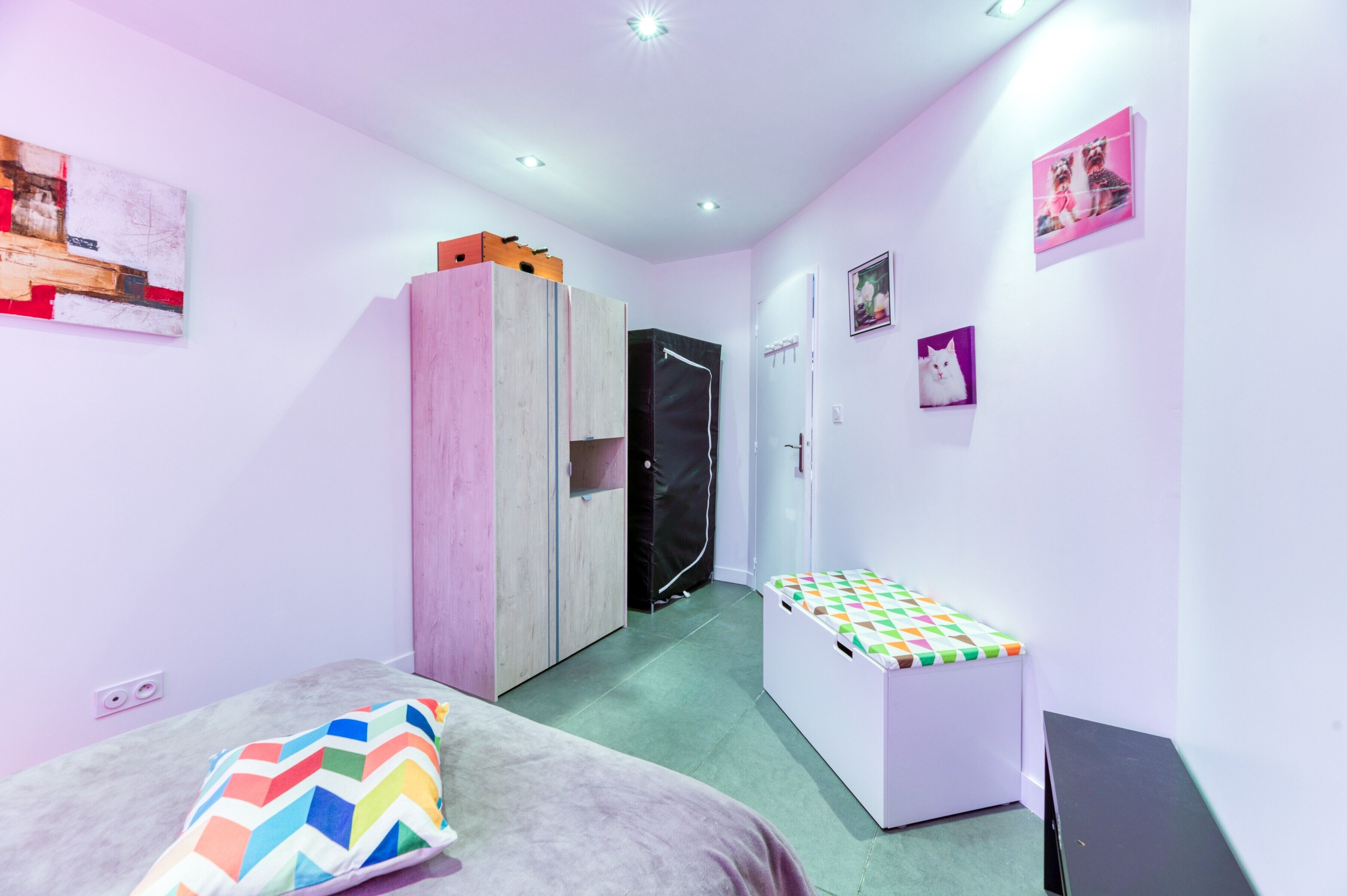 Une chambre à coucher avec un lit, une armoire, un banc et une porte.
