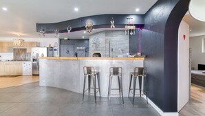 Een moderne keuken met een gebogen kookeiland, barkrukken en een stenen open haard.
