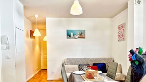 A dining area with a table set for four, a sofa, and a decorative sculpture. - Dream Vacation – Couples, Right by the Slopes (chamrousse)