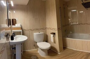 Kylpyhuone, jossa on pesuallas, wc ja kylpyamme.