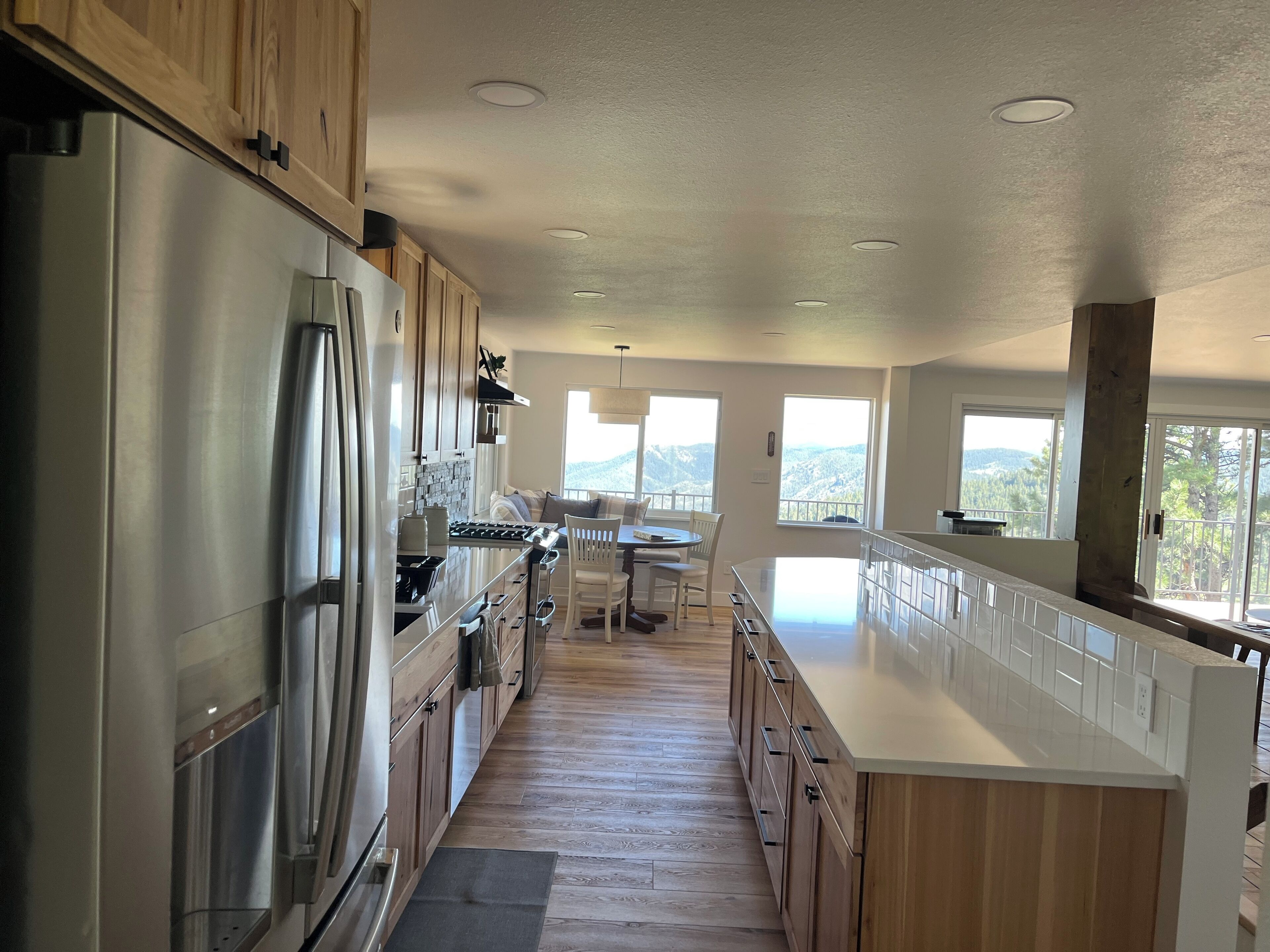 A modern kitchen with stainless steel appliances, wooden cabinets, and a central island.
