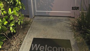 A gated entrance with a '1603' sign, a welcome mat, and surrounding greenery. - Charming 1-bedroom house in marvelous Fort Lauderdale with WiFi, AC, Parking (Fort Lauderdale)