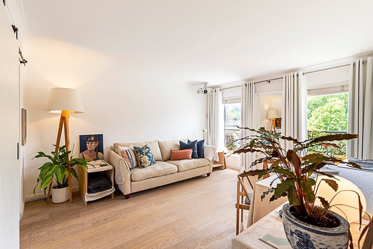A living room with a sofa, a coffee table, and a potted plant.