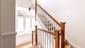 Eine Treppe mit Holzgeländern und beige gefärbten Stufen.