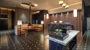 A modern lobby with a curved seating area, a reception desk, and a patterned floor.
