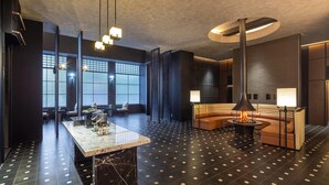 A modern interior with a marble bar, leather seating, and a fireplace.