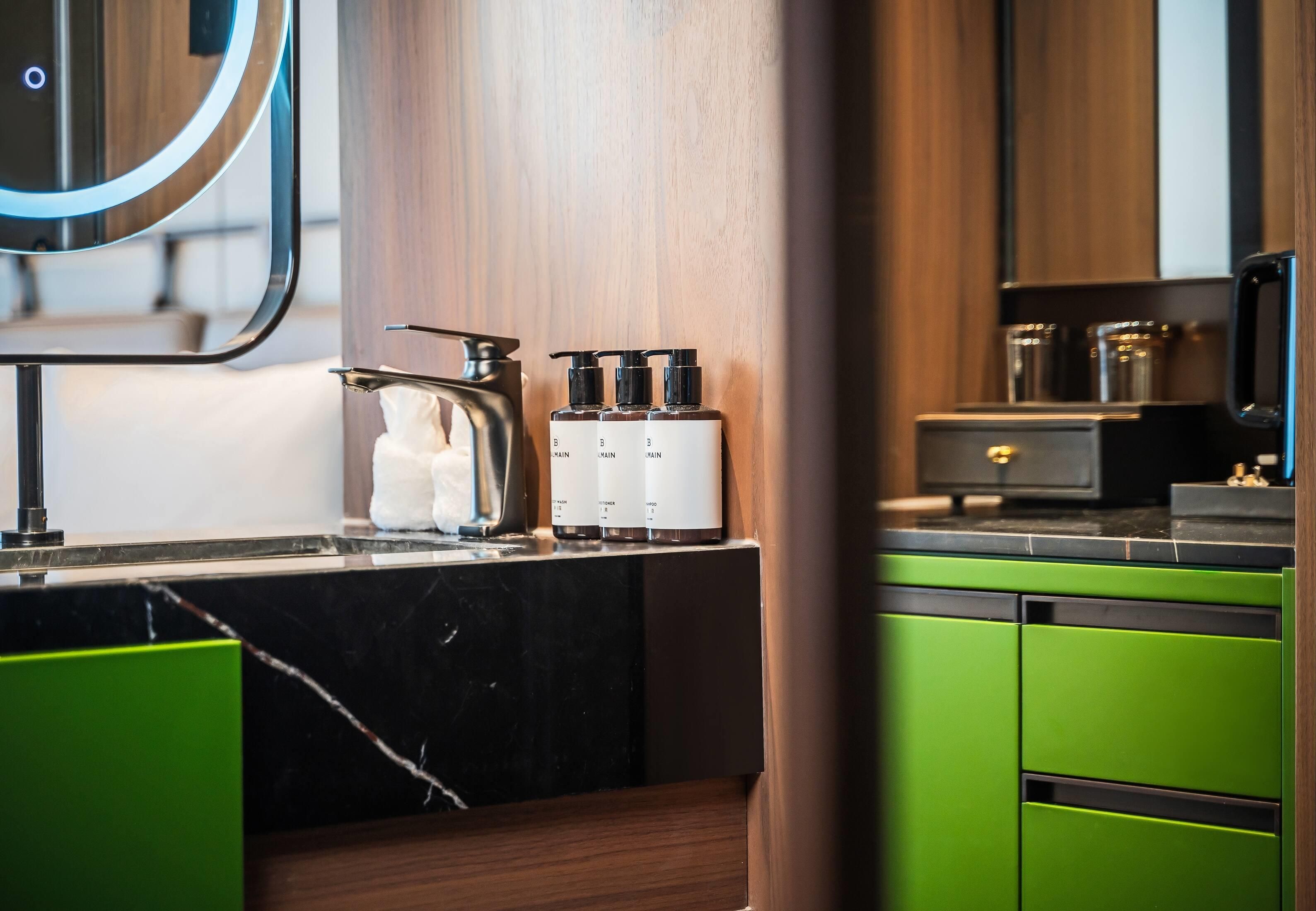 A modern kitchen with a marble countertop, a kettle, and a coffee machine.