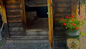 A wooden cabin with a sloped roof, a small porch, and a window. - Apartment with Panoramic View (Sankt Märgen)
