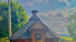 A small wooden cabin with a sloped roof, a wooden door, and a sign above the door. - Apartment with Panoramic View (Sankt Märgen)