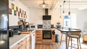 Een moderne keuken met houten kastjes, een inbouwoven en een magnetron.