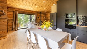 Una cocina moderna con una isla grande, electrodomésticos integrados y vistas al exterior.