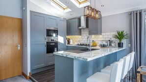 Una cocina moderna con una isla central, electrodomésticos integrados y un tragaluz.