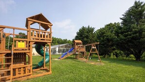 A playground with a slide and swings. - Mountain View Condo 1501 (Pigeon Forge)