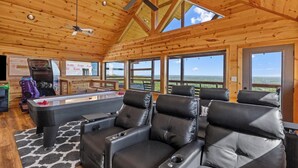 A wooden interior with a pool table, leather chairs, and a ceiling fan. - Dolly Valley View (Sevierville)