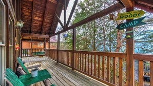 A wooden deck with benches and a sign indicating 'The Woods Camp'. - Catch Me If You Can (Pigeon Forge)