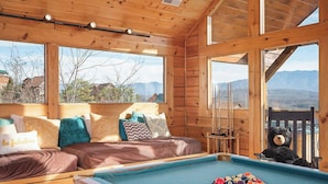 A cozy wooden cabin with a pool table, a bed with multiple pillows, and a view of mountains. - Sweet Slice of Heaven (Sevierville)