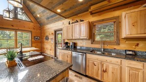 A modern kitchen with wooden cabinetry, granite countertops, and stainless steel appliances.