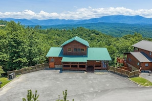 Un chalet doté d’un grand garage, d’un porche abrité et offrant une vue sur la forêt et les montagnes environnantes.