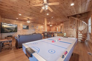 A wooden interior with a pool table, seating area, and ceiling fans. - Starr Crest Lodge (Sevierville)