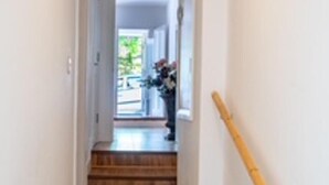 A narrow hallway with wooden stairs leading to a landing. - Orpington Cozy Retreat With 3 Bed (Orpington)