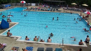 Une piscine dotée de plusieurs couloirs de nage, de chaises longues et de parasols.