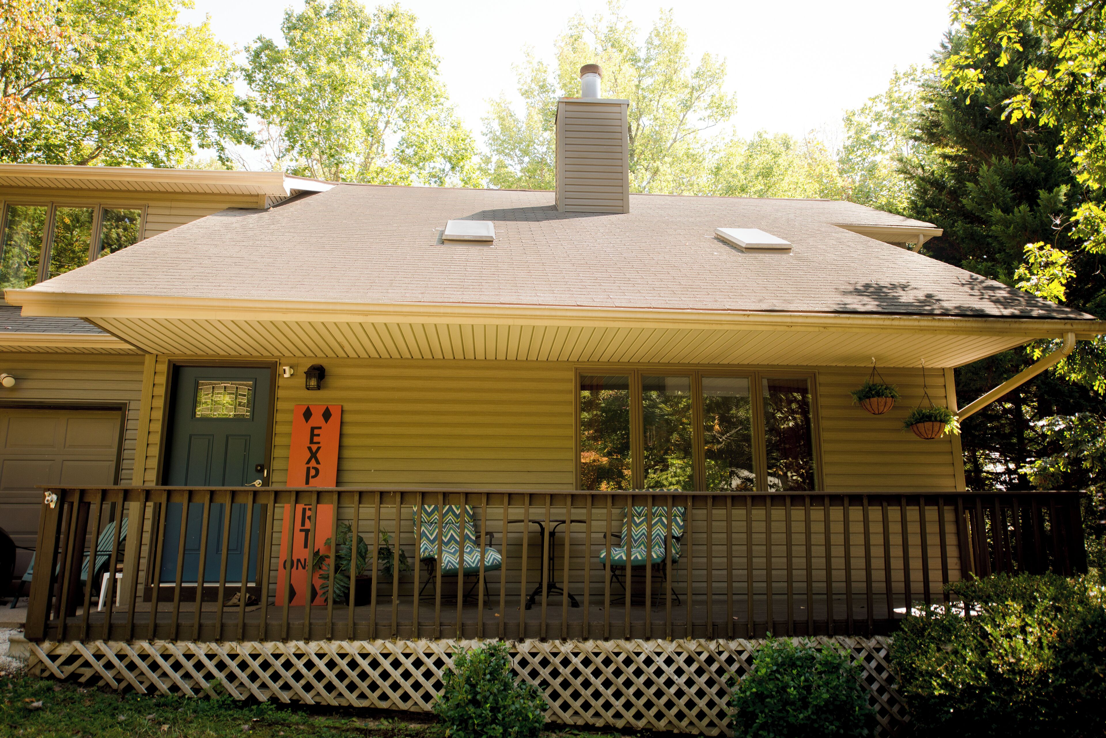 A two-story house with a covered porch, a chimney, and a garage.