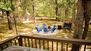Une terrasse dotée d’un jacuzzi, entourée d’une clôture en bois et d’arbres.