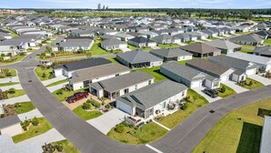 A residential area with multiple houses, roads, and green spaces. - Stylish Golfside Getaway (Wildwood)