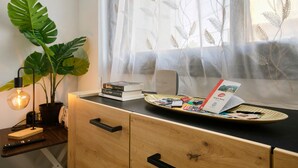 Un escritorio con una planta, libros, una bandeja con papeles y una lámpara.