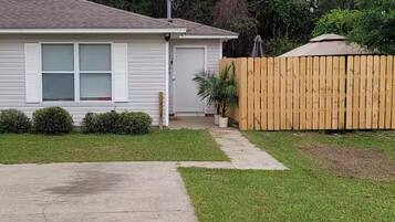 A single-story house with a front yard, a wooden fence, and a mailbox.