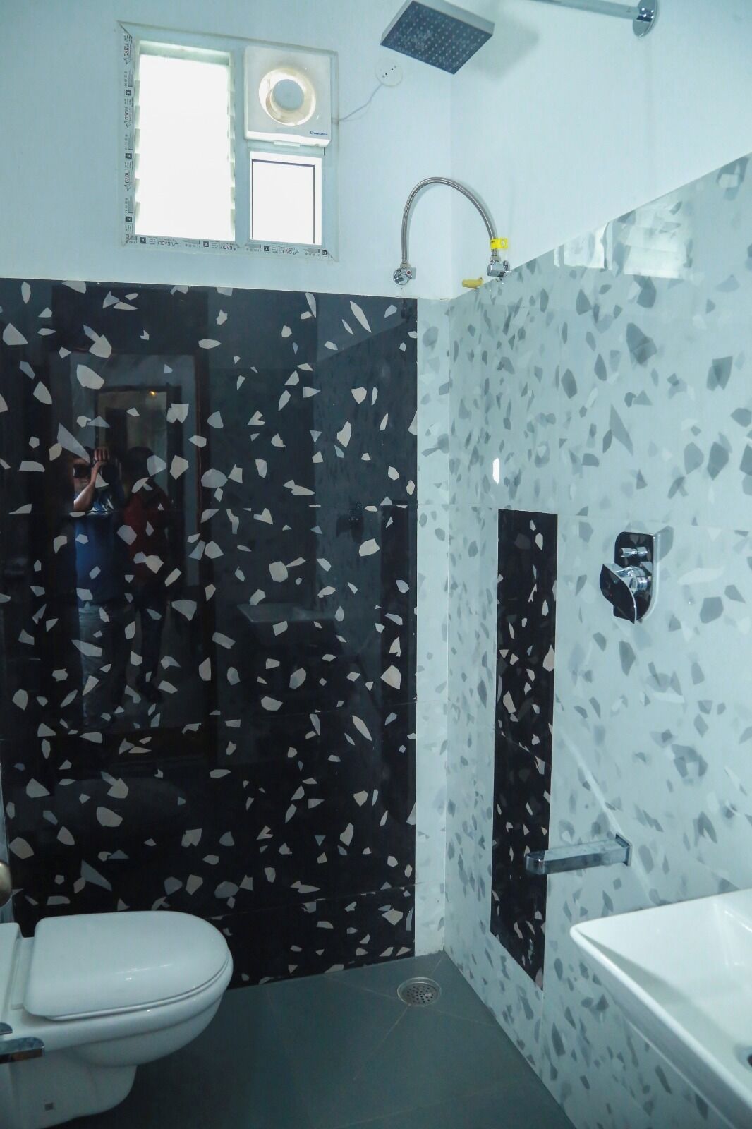 A bathroom with a toilet, a sink, and a shower area.