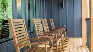 A covered porch with wooden rocking chairs and a ceiling fan.
