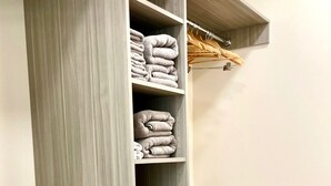 A walk-in closet with multiple shelves for folded clothes, a hanging rack, and a trash bin. - Stunning new loft in historic Union Block. Brand new, walk to everything. (Brigham City)