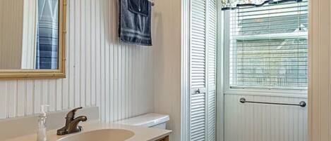 A bathroom with a sink, mirror, and toilet.