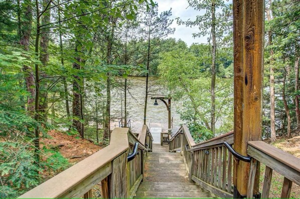 A wooden boardwalk leading through a forested area with a wooden structure at the end. - Riverfront Getaway - Mins to Waterparks/Downtown - Private 1st Floor Porches (Wisconsin Dells)