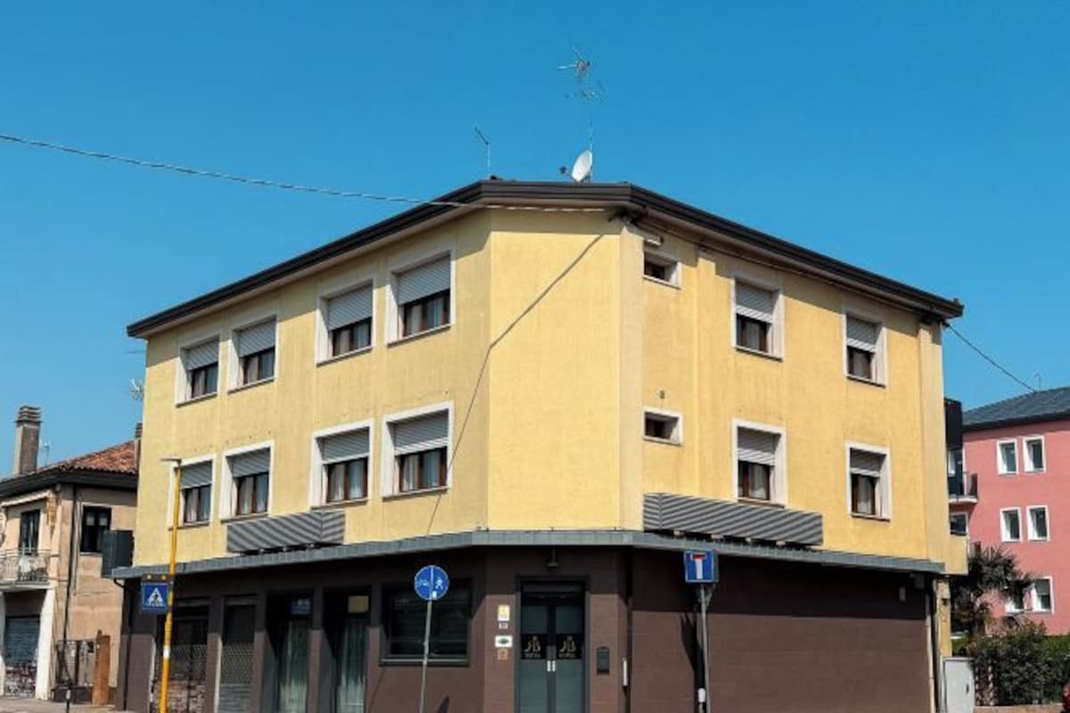 A multi-story building with a flat roof, several windows, and a visible entrance.