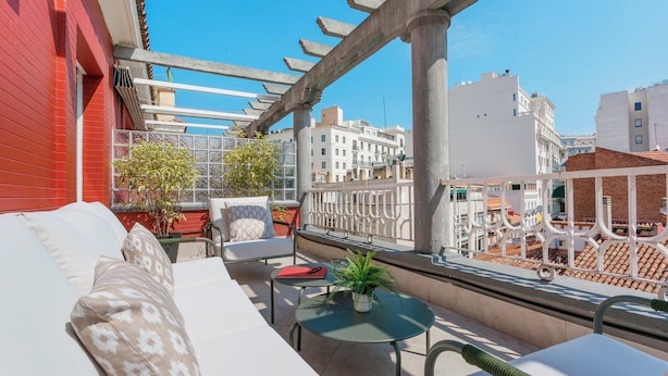 A balcony with a white sofa, a small table, and a potted plant. - Genteel Home Abada Terrace (Madrid)