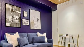 A modern living room with a blue sofa, a glass coffee table, and a dining area with a white table and chairs. - Freshly Remodeled Keystone Studio, Heated Pool, Hot tub, Walk to Gondola! (Keystone)