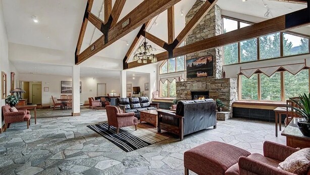 A spacious living area with stone flooring, a stone fireplace, and wooden beams. - Freshly Remodeled Keystone Studio, Heated Pool, Hot tub, Walk to Gondola! (Keystone)