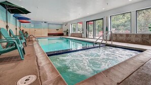 An indoor swimming pool with clear water, surrounded by turquoise chairs and a bench. - Freshly Remodeled Keystone Studio, Heated Pool, Hot tub, Walk to Gondola! (Keystone)