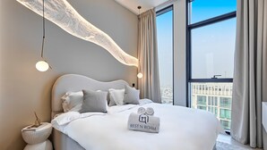 Une chambre d’hôtel moderne dotée d’un grand lit, offrant une vue sur la ville et présentant un design de plafond original.