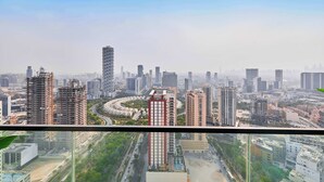 A cityscape with high-rise buildings, a roundabout, and a clear sky.
