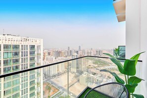 Een hoog gebouw met een glazen balkon met uitzicht op een stadslandschap.