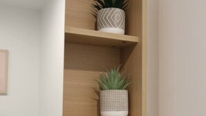 Una scaffalatura in legno con tre piante in vaso.
