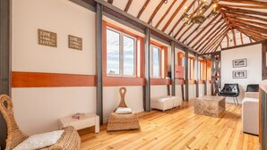 A spacious room with wooden floors, wicker furniture, and a high ceiling with exposed beams. - GuestReady - Alfama Terrace B1 (Lisbon)