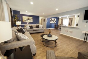 A modern living room with a sofa, coffee table, and dining area.