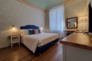 A bedroom with a bed, bedside tables, a desk, a mirror, and a window with curtains. - Lo Strullo - First Floor Minisuite (Pisa)