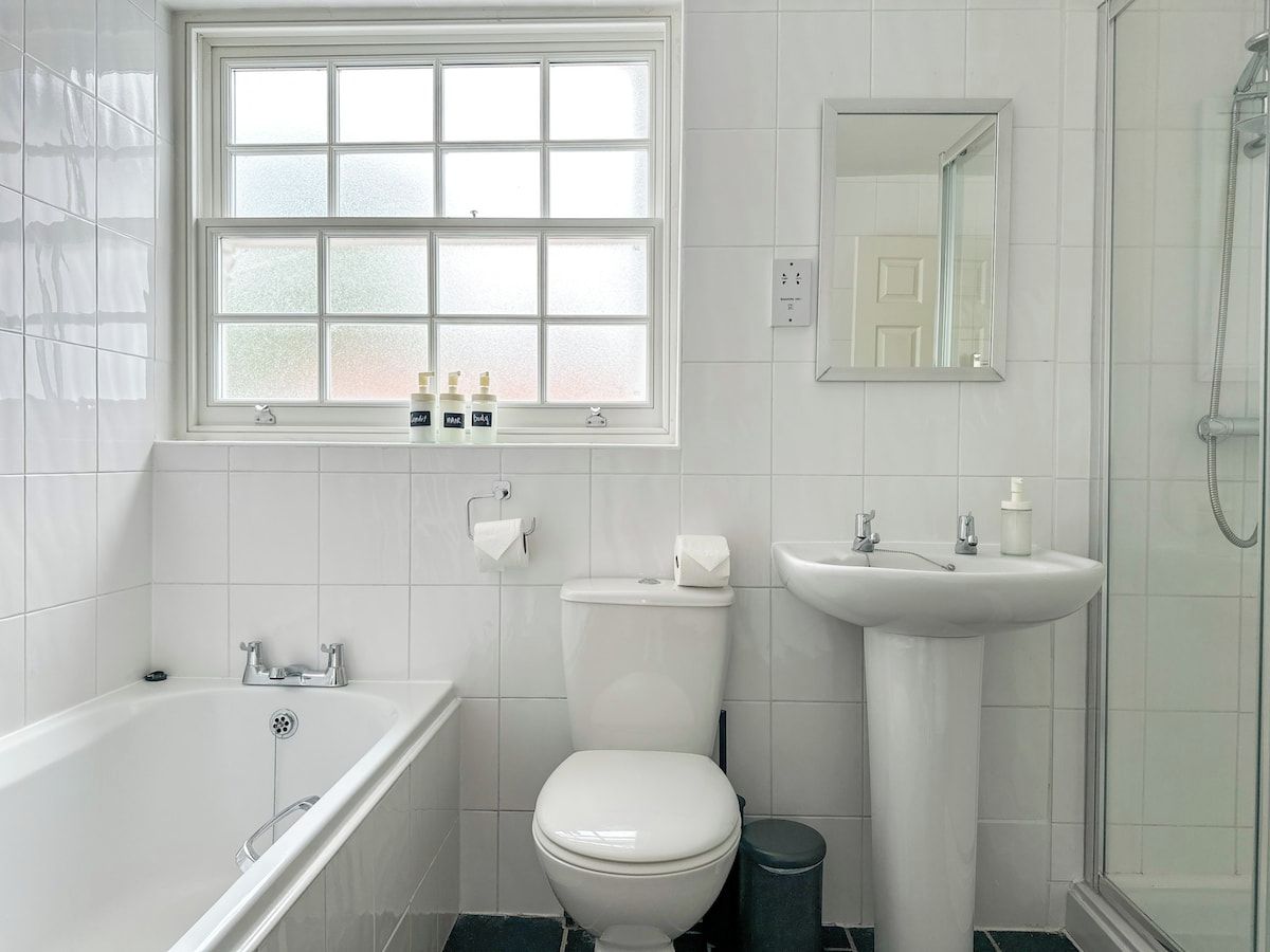 Un baño con bañera, inodoro, lavabo y ducha.