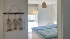 Ein Schlafzimmer mit einem Bett, einer hängenden Fischdekoration und einer Deckenleuchte.